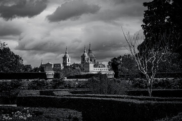 views of the Monastery of El Escorial and its historic gardens surrounded by autumn trees and spectacular skies.