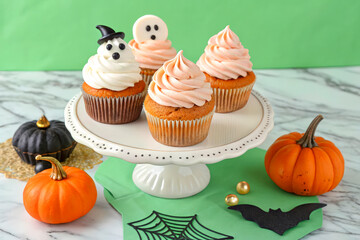 Halloween Themed Cupcakes with Ghosts and Pumpkins on a Display Stand