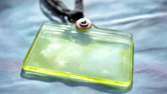 A vibrant lime-green plastic identification badge rests on a light blue surface.