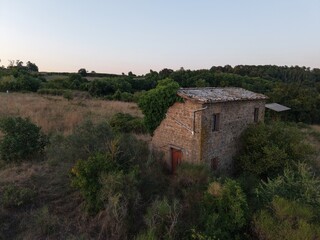 Fototapeta premium Rural landscape with stone house and vegetation, Lake Bolsena region