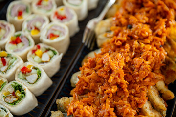 Enjoy a flavorful Asian cuisine platter with rolls and spicy topping, perfect for any occasion