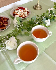 Sommerliches Buffet mit Blätterteigrosen, Vanilleeis und Obstdeko auf grün gedecktem Tisch goldene Tischdeko Anlass Hochzeitdeko Partybuffet