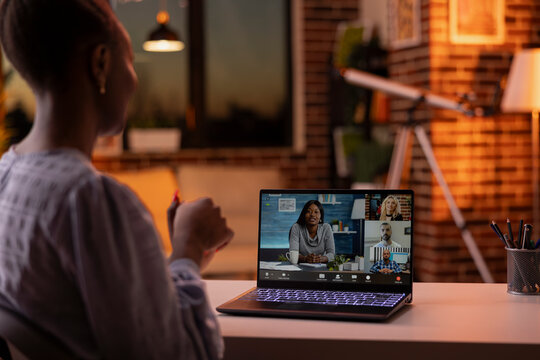 Black woman focused on productive online conversation with diverse professionals, attending virtual business call on laptop. Self employed female individual talking during video conference meeting.