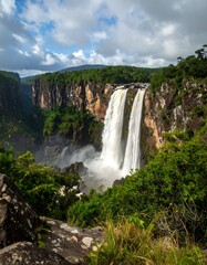 Obraz premium Majestic twin waterfalls cascading over lush rainforest cliffs
