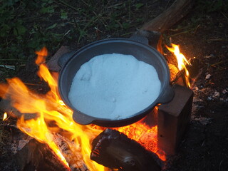 fire in a fireplace The first firing of the cauldron over an open fire with table salt