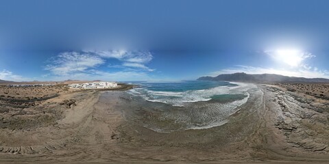 Famara coastal town with sandy beaches on Lanzarote island captured in aerial panoramic view Canary islands Spain