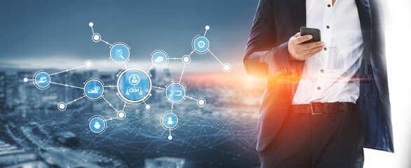 A business professional is engaged with a smartphone in an urban setting, showcasing digital connectivity and data visualization that represents the modern technology landscape. Tessel