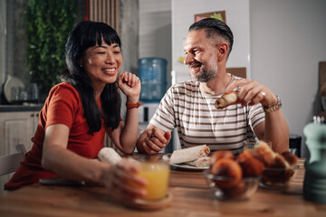 Happy couple enjoying breakfast together in modern kitchen