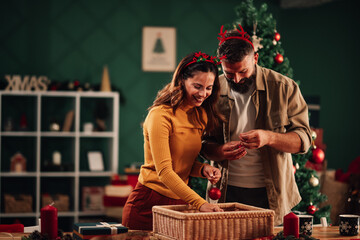 Happy couple decorating home for christmas holidays together