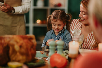 Happy family celebrating thanksgiving dinner, mother and daughter sharing a special moment