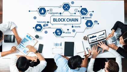 A diverse team of business professionals collaborates over blockchain technology, highlighting...