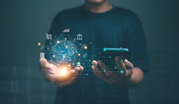 Global digital finance and technology concept. Businessman holding smartphone with hologram earth and fintech icons. Online banking, e-commerce, AI and data innovation. Online transactions.