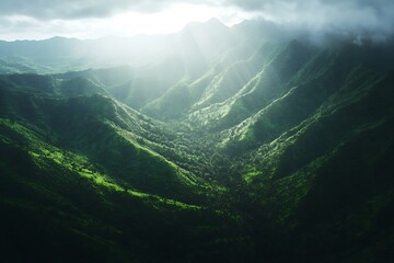 A serene view of lush green mountains under soft sunlight breaking through clouds.