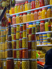 CLOSE UP: Vibrant market stall with an abundance of preserved foods. Stacked jars of colourful pickles, olives and vegetables are create rich tapestry of textures and hues, typical of Moroccan souk.