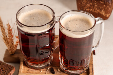 Glasses of fresh kvass with bread and wheat on white background