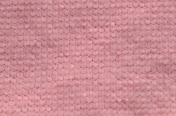A cozy macro photograph showing the fine, uniform loops of a gentle pink textile, perfect for warm and comfortable textural backgrounds.