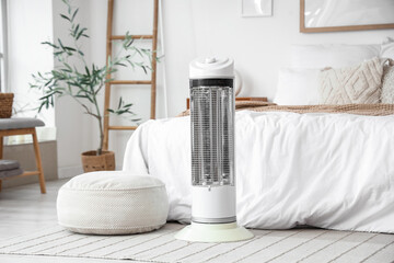 Electric heater on rug in bedroom