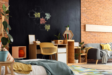 Stylish interior of teenager's room with chalk drawing on black wall