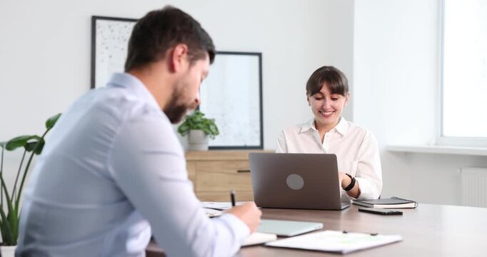 Man feeling jealous of his successful colleague receiving congratulations in office