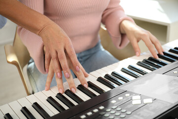 Obraz premium Tutor teaching woman to play piano indoors, closeup