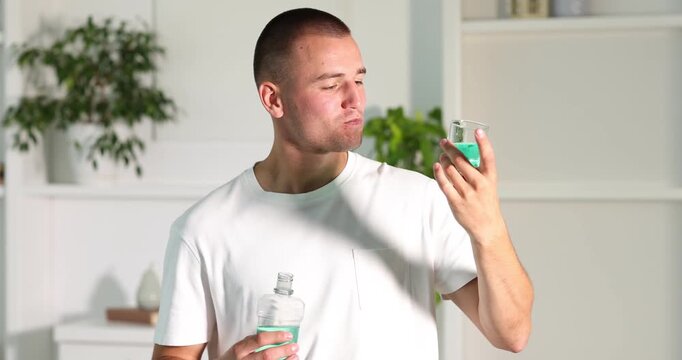 Man rinsing mouth with mouthwash at home