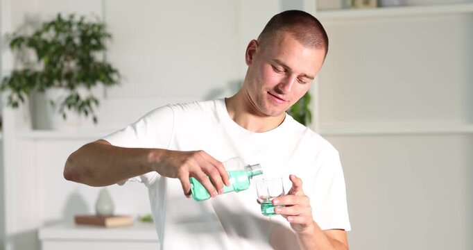 Man rinsing mouth with mouthwash at home