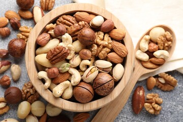 Mix of different nuts on grey table, flat lay