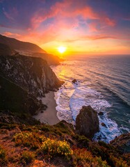 Fototapeta premium A breathtaking coastal sunset over dramatic cliffs, highlighting a secluded beach and vibrant colors.