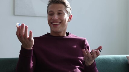 Man choosing between glasses and contact lenses on sofa indoors, camera moving in
