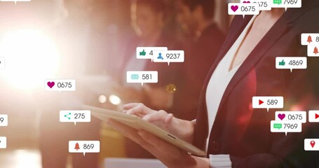 Businesswoman tapping tablet and causing icons showing social media engagement surge with team - Powered by Adobe