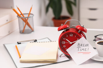 Paper with text BREAK TIME, alarm clock and coffee cup on desk in office, closeup