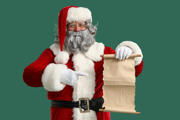 Santa Claus pointing at letter on green background