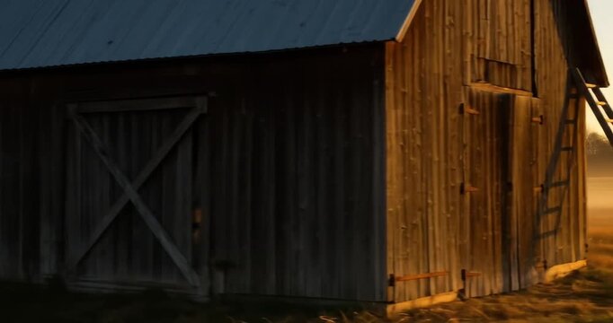 Rustic barn at sunrise with ladder and foggy field