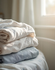 Stack of Neatly Folded White and Light Blue Bedding near Window