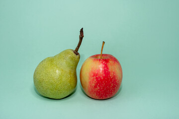 pear and apple close up on plain green background