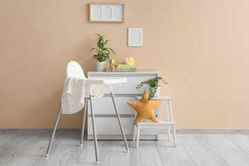 Interior of room with baby highchair, commode and blank frames