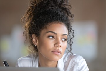Thoughtful african female adult working in casual office environment