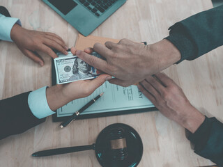 A lawyer or judge gives a bribe to a client after signing a contract document. Corruption in the...