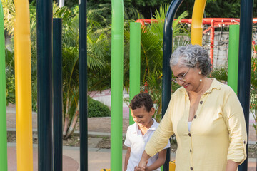 Obraz premium Grandmother and grandson holding hands walking in park