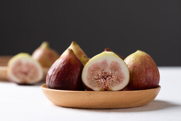 Fresh fig on wooden plate with white and black background, Autumn fruit