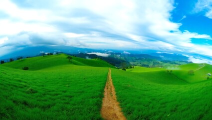 Obraz premium Vast green meadow stretches to distant mountains under a dramatic cloudy sky