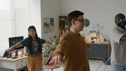 Three programmers standing in center of IT office and doing exercise for back during workday - Powered by Adobe