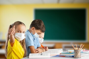 Group of school students sitting in classroom studying.