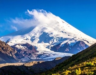 Fototapeta premium A majestic snow-capped mountain peak rises against a vibrant blue sky, its slopes covered in pristine white snow and dramatic, shadowed valleys.
