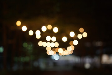 Abstract bokeh lights background at night, soft focus warm yellow light orbs, festive glowing illumination, perfect for Christmas, New Year, or celebration design template.