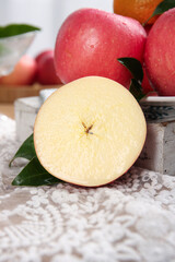 Fresh Red Apples Cut in Half Display on Ice with Green Leaves in Wooden Crate