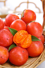 Fresh Persimmons in Basket with Cut Fruit Showing Orange Flesh - Healthy Organic Produce Display