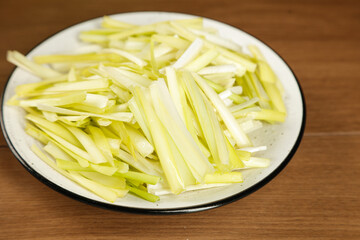 Fresh Yellow Leek Julienne Strips on White Plate - Vegetable Preparation for Cooking