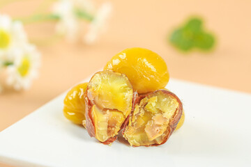 Raw Chestnut Kernels with Exposed Golden Fruit Flesh and Brown Shells on White Plate