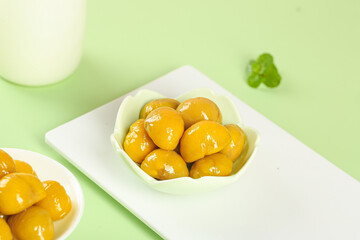 Glazed Chestnuts in White Bowls on Green Background - Sweet Preserved Fruit Dessert